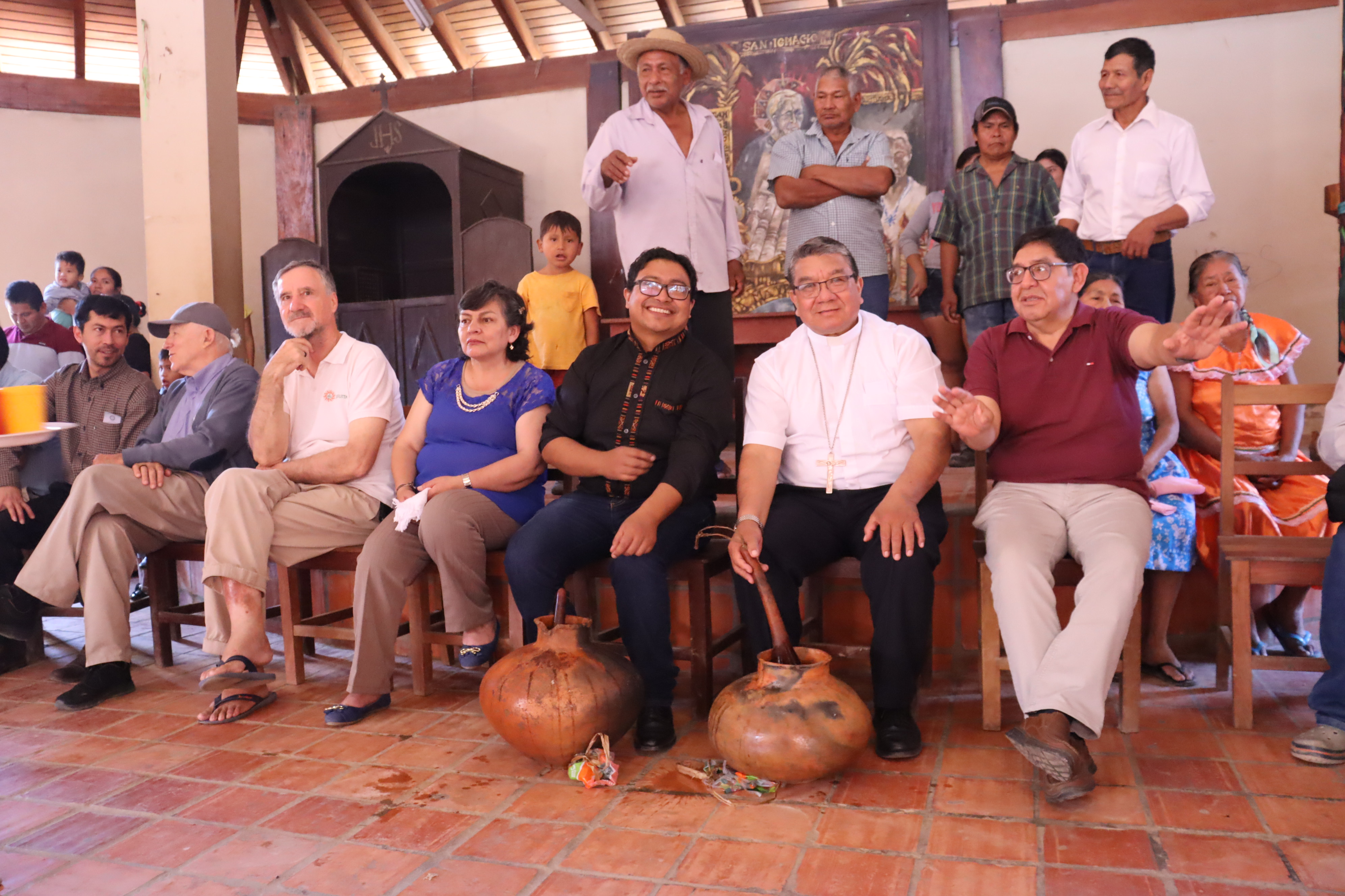 El padre Ramiro Loza junto al obispo Pessoa (centro) “maripeando” el cántaro de chicha.