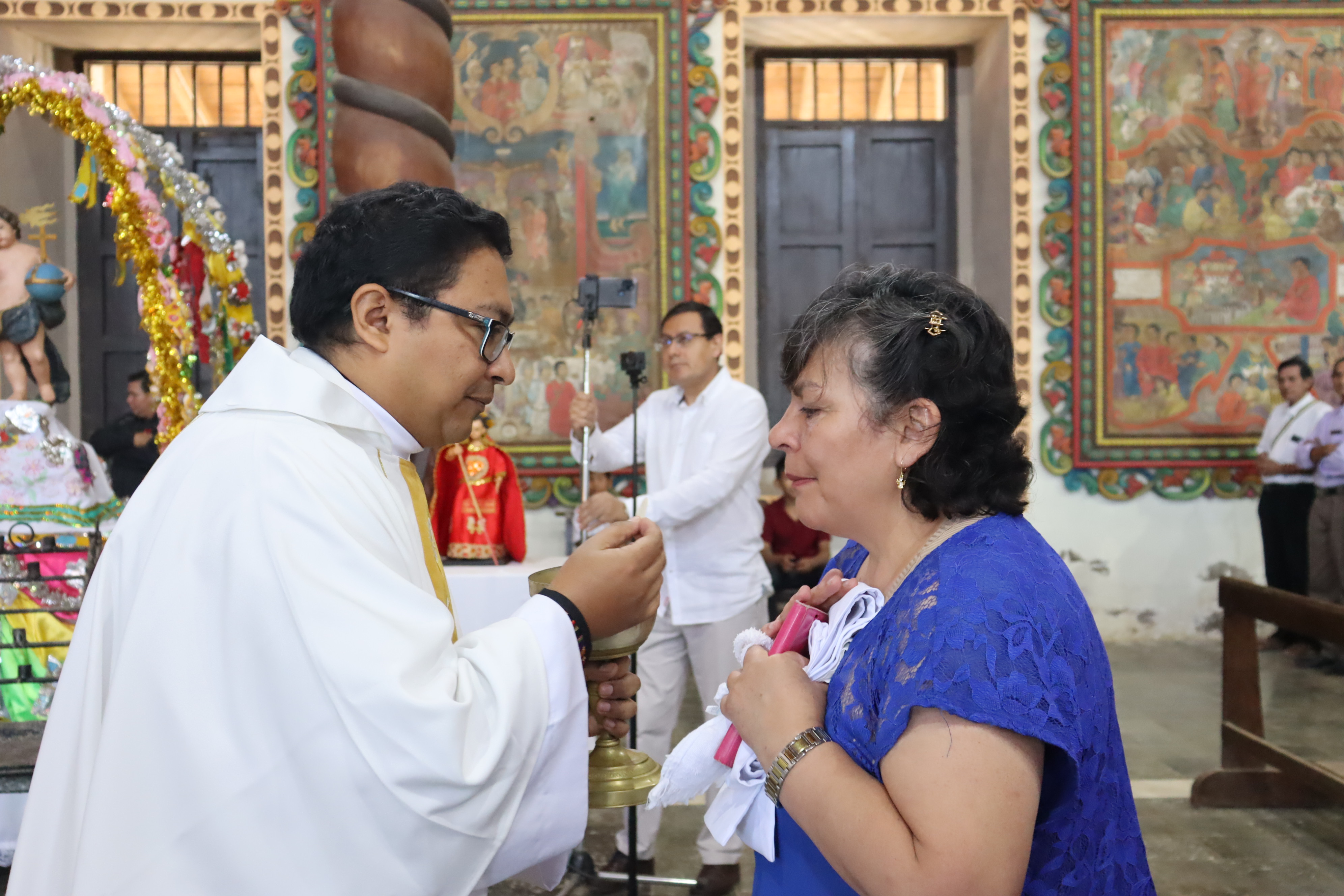 El padre Ramiro Loza SJ. entrega la comunión a su madre 